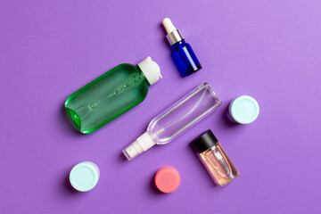 Cosmetics SPA branding mock-up, top view with copy space. set of tubes and jars of cream flat lay on colored background