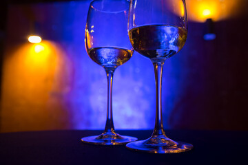 Wine glasses stand on the table on a blue background