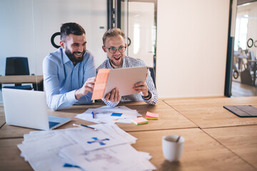 Emotional male colleagues satisfied with making great ideas and solution on cooperating process in office, men business partners having fun and happy with completing strategy planning together