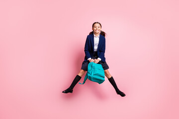 Fototapeta na wymiar Full length body size view of her she nice attractive pretty funny cheerful cheery small little girl jumping wearing socks gaiters holding blue bag isolated over pink pastel color background