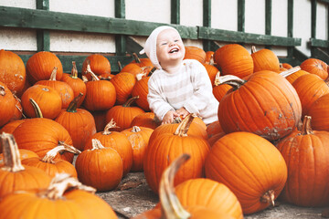 Child picking pumpkins at pumpkin patch.