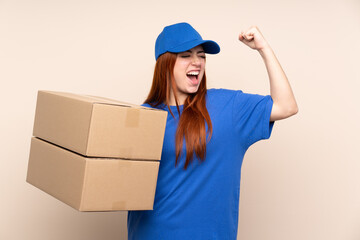 Young teenager delivery girl over isolated background celebrating a victory