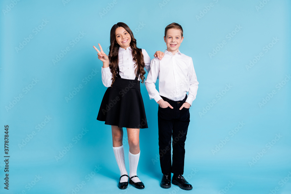 Poster Hello schoolkid. Full length photo of two girl boy model schoolchildren classmates sister brother show v-sign wear uniform white shirt black pants dress shoes isolated blue color background