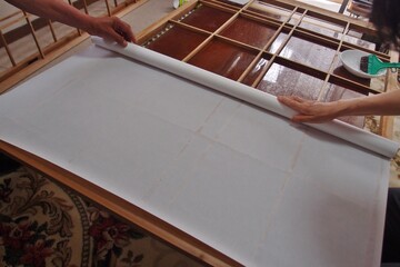 Replacing shoji paper of a traditional sliding door in Japan. - obrazy, fototapety, plakaty