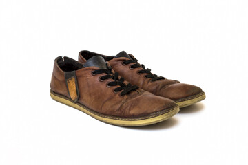 Old dirty brown leather shoes on an isolated white background. Concept, second hand, hard work, walking, worn out pair of lace-up low shoes. High quality photo