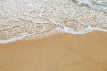 Fototapeta na wymiar Closeup white wave on empty sand beach, nature texture background, outdoor day light