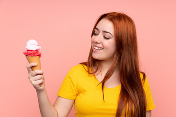 Young girl with a cornet ice cream over isolated background with happy expression