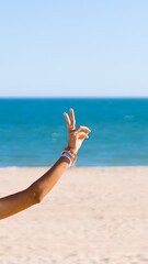 showing v sing with her hand in the beach. Peace concept. Sign of gestures. Isolate. Copy space.