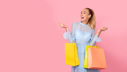 Overjoyed woman with shopping bags looking at copy space