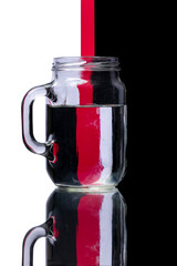 Glass Mug of Water Reflecting Black White and Red Background