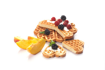 Waffles with berries and peaches isolated on white background