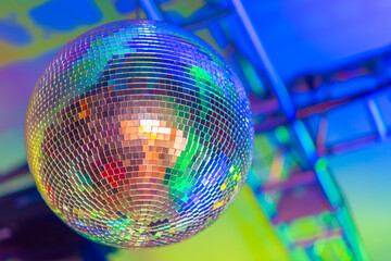 Big disco ball on a colored background in a nightclub