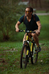 Fototapeta premium Young man cycling on bicycle in the public park