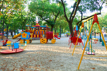 Fototapeta na wymiar children's playground in a city Park early in the morning, various swings and carousels