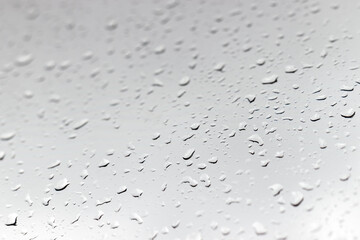 Raindrops on a window glass in rainy cloudy day against a gray sky. Autumn, depressive, rainy weather. Selective focus