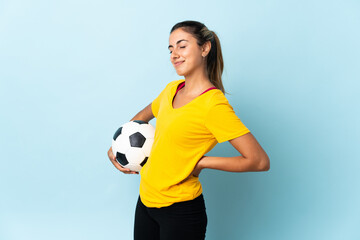 Young hispanic football player woman over isolated on blue background suffering from backache for having made an effort