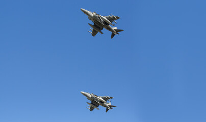 Modern armed military fighter jets flys in formation through the sky.
