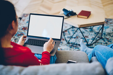 Woman typing on laptop in living room