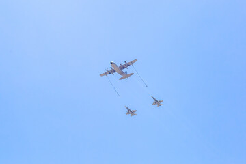 Modern armed military fighter jets flys in formation through the sky.