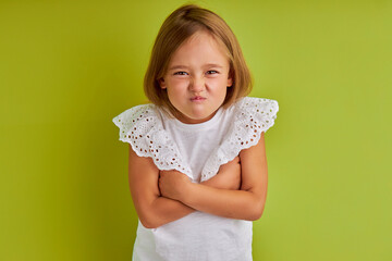 caucasian emotional little girl puff out, isolated background. look at camera