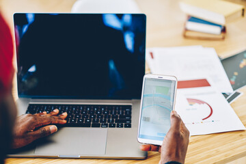 African American man using GPS navigator on smartphone in office