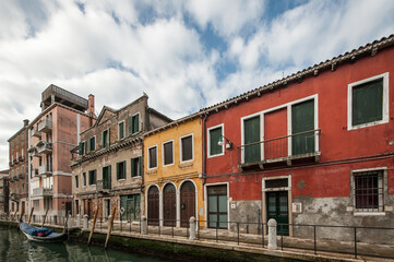 Fototapeta na wymiar Streets of Venice with a typical waterl canal during a cloudy day, Italy