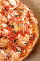 Homemade pizza with cheese and tomatoes on thin crust. Do it yourself pizza with pasta. Vertical photo.