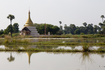 Inwa Island, Mandalay, Myanmar, stupa and temple in landscape reflected in water