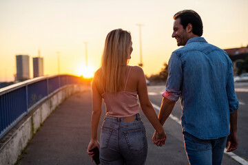 Couple walking towards sunset on the street