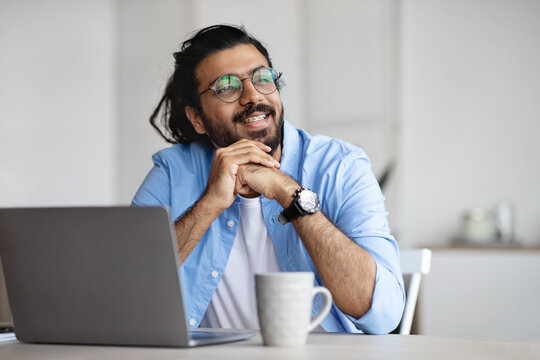 Pensive Freelancer Thinking About Something While Working On Laptop At Home Office