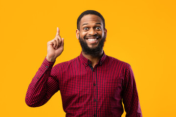 Excited black man having great idea and pointing up