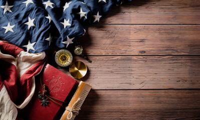 Happy Columbus Day concept. Vintage American flag with compass and treasure manuscript with copy space on dark wooden background.