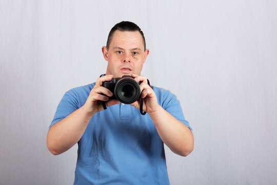 man with down syndrome with camera on white background