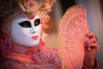 Beautiful carnival costume/mask posing during sunrise at the annual carnival in Venice, Italy