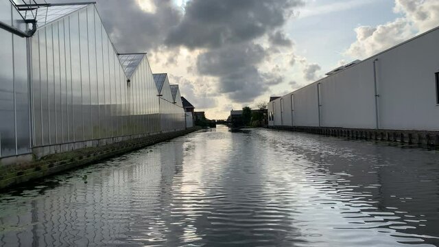 Sailing in the Dutch polder in between greenhouses