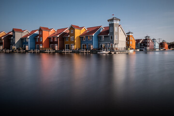 Colorful houses alongside a water canal during a sunny day in Groningen, Netherlands