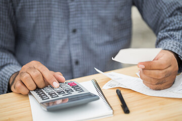 Businessman using calculator and calculate bills of payment per month. Financial buying payment income expenditure.