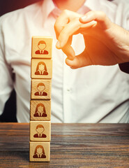 Man knocks down a tower of blocks with employees. Mass layoffs, closing a business company....