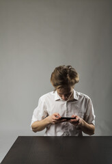 Fototapeta premium Young man in white using smartphone.
