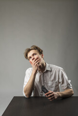 Young man in white using smartphone.