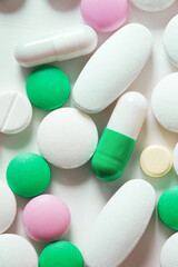 tablets and pills of various shapes on white background close up top view. minimalistic concept of medicine and treatment