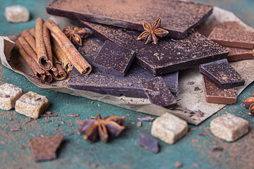 Dark and milk chocolate chunks, cocoa powder, cinnamon, anise star and brown sugar. Confectionery shop advertising and cooking ingredients concept.