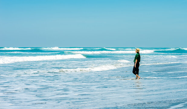 single girl enjoys herself standing on  Parangtritis beach, Yogyakarta, Indonesia.