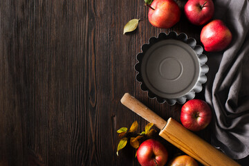 Autumn cooking theme with pie pan and apple  and leaf on dark wooden background