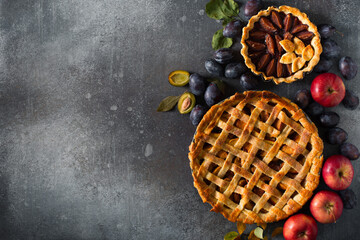 Autumn and summer pie with apple plum on dark  background