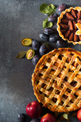 Autumn and summer pie with apple plum on dark  background
