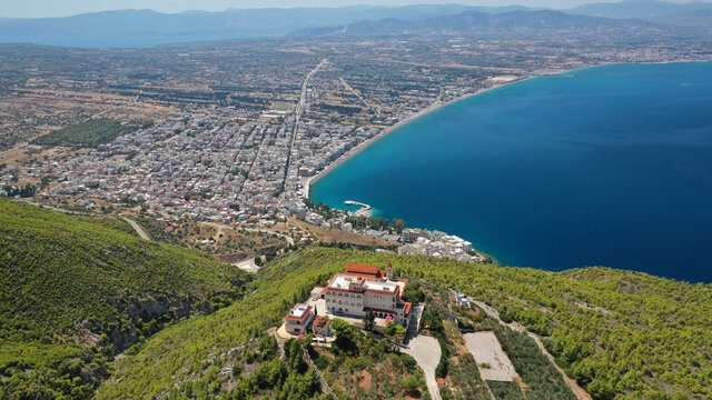Aerial drone photo of iconic monastery Prophet Elias or Profitis Ilias built on top of a cliff overlooking Loutraki town, Corinthian bay, Greece