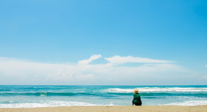 single girl enjoys herself standing on  Parangtritis beach, Yogyakarta, Indonesia.