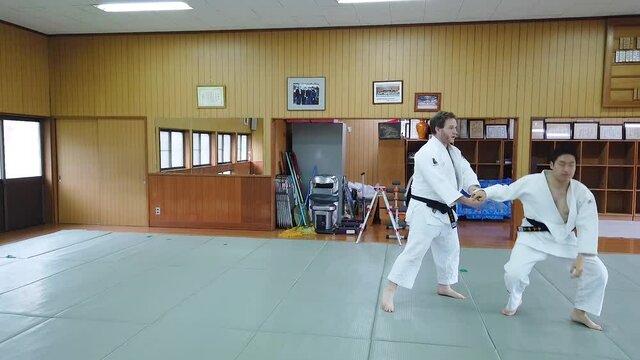 Two Judo Black Belts practice a Major Inside Sweep (Ouchi Gari) during practice at a Traditional Japanese Dojo.