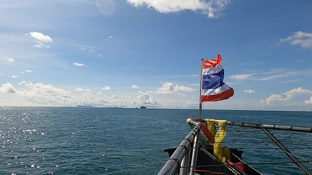 view of Thai nation flag blowing at front of the boat or ship will go to island and blue sky summer, 59.94fps.